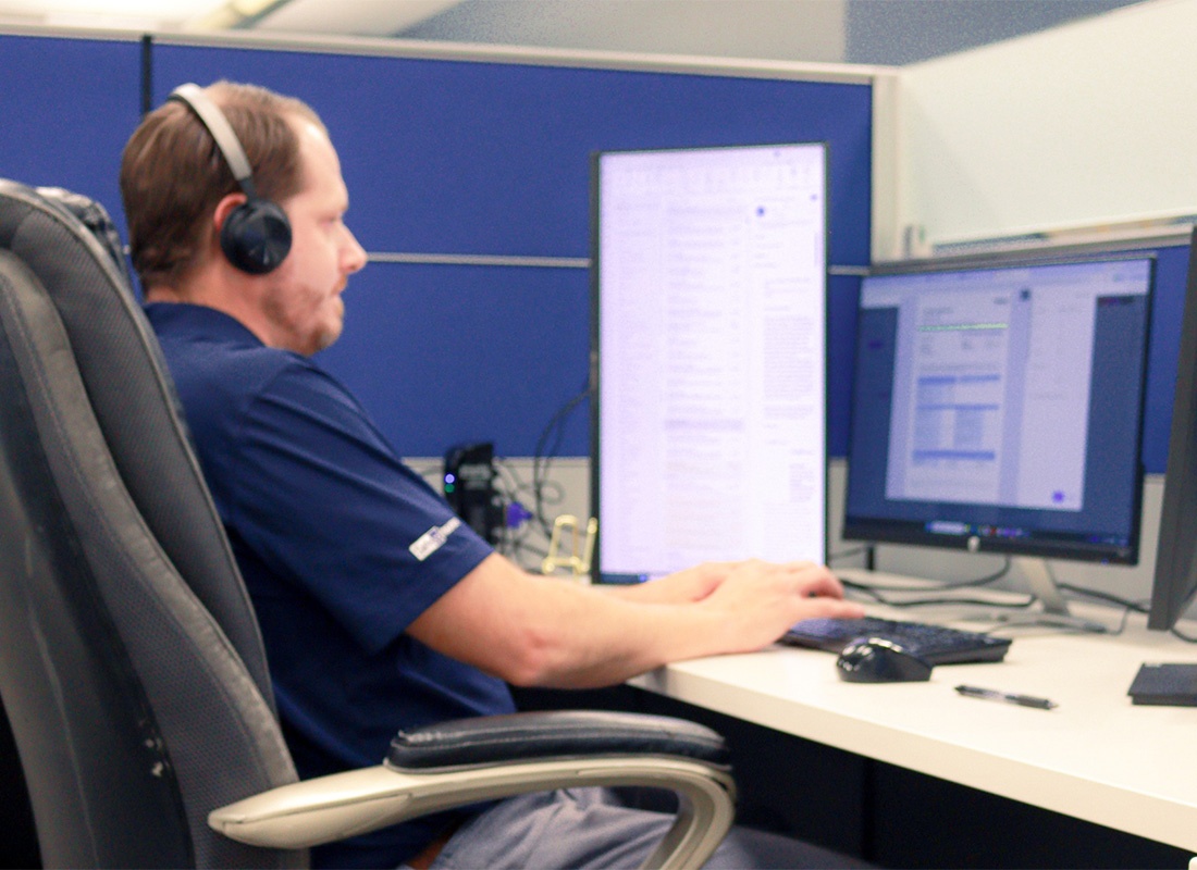 Service Center - Team Member Working on the Computer and Helping Out a Client